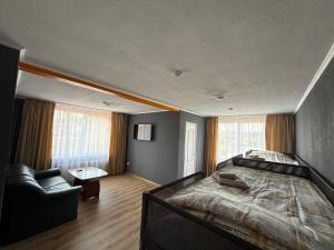 a bedroom with a large bed and a chair at ADAM Hostel Krāslava in Krāslava