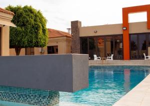 a swimming pool in front of a building at Fanky Hotel in Palatswe +3 photos