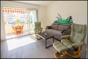 a living room with a couch and chairs and a table at L'ariot 1984 - appartement cosy avec terrasse, parking et wifi in Sète