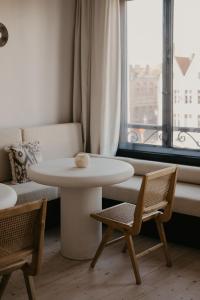 a white table and chairs in a room with a window at Isidore in Bruges