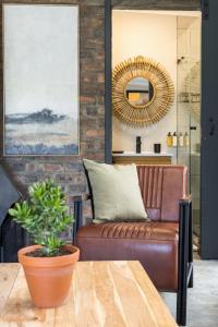 a living room with a brown leather couch and a table at Avemore Time Out Le Verger in Stellenbosch