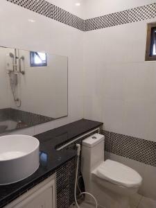 a bathroom with a sink and a toilet and a mirror at House in the heart of Kamala in Kamala Beach