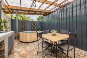 a patio with a table and chairs and a hot tub at Avemore Time Out Le Verger in Stellenbosch