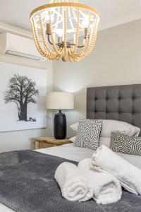 a bedroom with a bed and a chandelier at Avemore Time Out - full power back up in Stellenbosch +47 photos