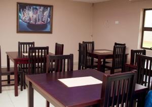 a dining room with tables and chairs and a painting at Fanky Hotel in Palatswe