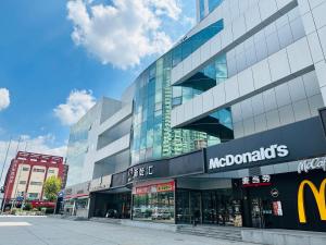 ein McDonald's-Laden vor einem hohen Gebäude in der Unterkunft JI Hotel Shanghai Caohejing Hongcao Road in Shanghai