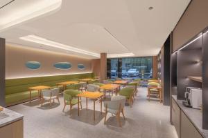 un ristorante con tavoli e sedie in una caffetteria di JI Hotel Beijing South Railway Station North Square a Pechino