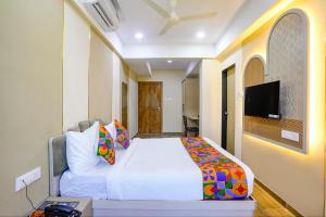 a bedroom with a bed and a tv on a wall at FabHotel Melody NX in Thane