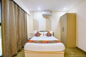 a bedroom with a large bed with colorful pillows at FabHotel Melody NX in Thane