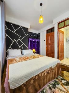 ein Schlafzimmer mit einem großen Bett und einem lila Fenster in der Unterkunft Fly Africa village 3 in Arusha