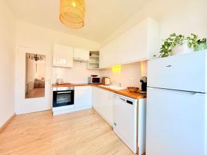 a kitchen with white cabinets and a white refrigerator at Vue rivière imprenable, 2 chambres, centre-ville in Besançon