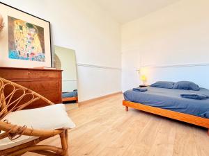 a bedroom with a bed and a chair in it at Vue rivière imprenable, 2 chambres, centre-ville in Besançon