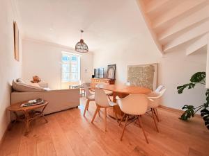 a living room with a table and chairs and a couch at Vue rivière imprenable, 2 chambres, centre-ville in Besançon