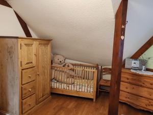a room with a crib with a teddy bear in it at Maison Alsacienne in Nothalten