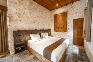 a bedroom with a bed in a stone room at Imalee - Cottage in Yogyakarta +85 photos