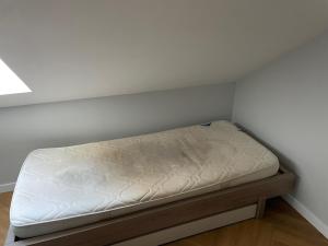 a small bed in a corner of a room at Loft industriel - hyper centre cambrai in Salles-sur-Mer