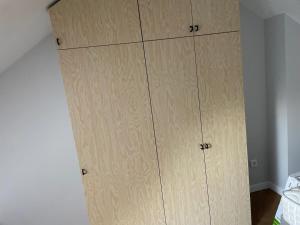 a closet with wooden cabinets in a bedroom at Loft industriel - hyper centre cambrai in Salles-sur-Mer