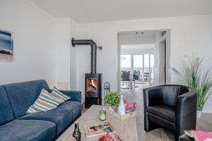 a living room with a blue couch and a fireplace at Maisonette Fewo Kapteins Lounge by Seeblick Ferien ORO, Rundum Wasser, 6Pers, Sauna, Kamin in Olpenitz