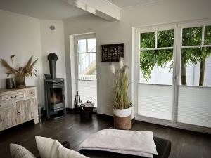 a living room with a couch and a wood stove at Traumferienhaus Sliminde by Seeblick Ferien ORO, direkte Wasserlage E-Säule 6 Pers in Olpenitz