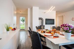 a kitchen and dining room with a table and chairs at Schleivilla Lootsen Hus by Seeblick Ferien ORO, 3Etagen,8Pers,Sauna,Kamin in Olpenitz