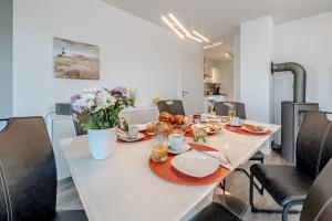 a white table with food and flowers on it at Schleivilla Lootsen Hus by Seeblick Ferien ORO, 3Etagen,8Pers,Sauna,Kamin in Olpenitz