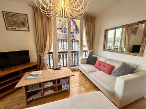 a living room with a white couch and a table at Hyper Centre DEAUVILLE 3 chambres in Deauville
