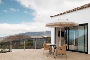 a patio with a table and chairs and an umbrella at Finca el Moral by Huskalia in Los Llanos de Aridane +136 photos