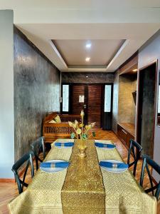 a dining room with a long table with blue plates at Khum Lanna Boutique Hotel in Si Sa Ket +153 photos