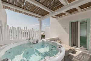a jacuzzi tub on a balcony with a view at Majo Suites Hotel in Agia Anna Naxos