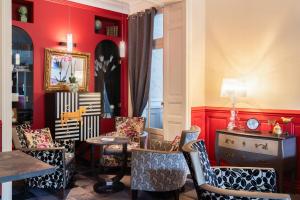 a living room with red walls and chairs at The Originals Boutique, Hôtel Normandie, Auxerre in Auxerre