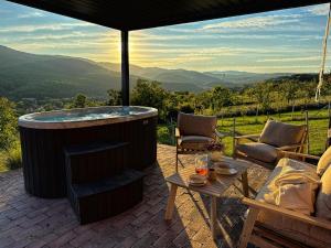 a hot tub on a patio with a table and chairs at Bükk Hill Garden in Miskolc