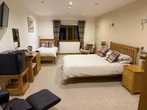 オークニー諸島にあるAvalon Guest Houseの広いベッドルーム(ベッド2台、テレビ付)