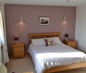 オークニー諸島にあるAvalon Guest Houseの大きなベッドと2つのナイトスタンドを備えた寝室