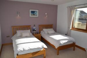 オークニー諸島にあるAvalon Guest Houseのベッド2台と窓のある寝室