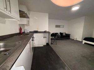 een keuken en een woonkamer met een bank bij Cosy Modern Studio Apartement in Ilkeston