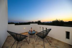 a patio with two chairs and a table on a balcony at Eleonas 2 in Maragkas