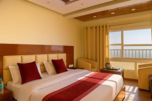 a hotel room with a large bed with red pillows at Hotel Samrat - On Mall Road in Mussoorie +38 photos