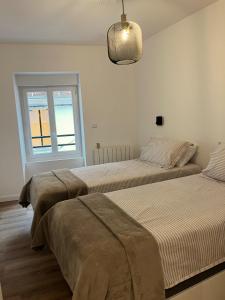 twee bedden in een kamer met een raam bij Le Vieux Bourg Apartment 2 in Le Bourg-dʼOisans