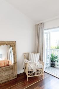 1 dormitorio con espejo grande y silla en La Palma Sunshines Heart beside The Village, en Sunshine Beach