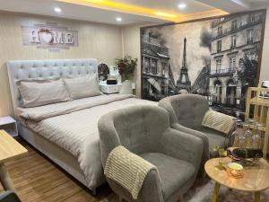 een slaapkamer met een groot bed en twee stoelen bij Sunflower Homestay Hai Phong in Hai Phong +76 foto's