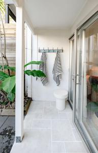 Un baño con inodoro y ventana. en La Palma Sunshines Heart beside The Village, en Sunshine Beach