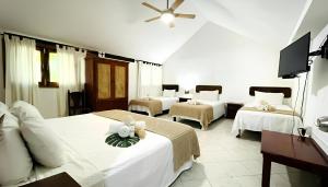 a hotel room with three beds and a flat screen tv at Hotel B&B - 5th Avenue in Playa del Carmen +103 photos