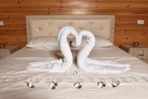 two swans are made to look like hearts on a bed at אחוזת אודליה במושב דלתון in Shahar +10 photos