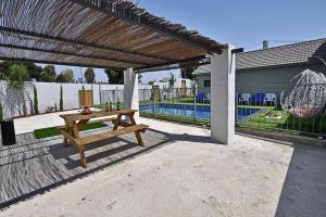 a wooden picnic table under a wooden pergola at אחוזת אודליה במושב דלתון in Shahar