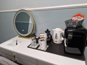 ペイントンにあるAmbassador Guest Houseのバスルーム(コーヒーメーカー、鏡付)