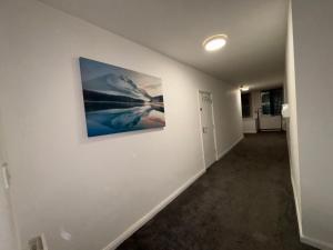 een lege hal met een schilderij aan de muur bij Cosy Modern Studio Apartement in Ilkeston +3 foto's