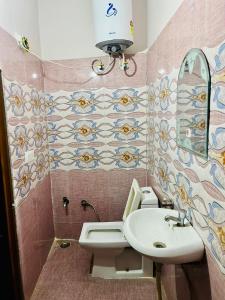 a bathroom with a sink and a toilet and a mirror at Hotel Krishna Gorakhpur in Gorakhpur