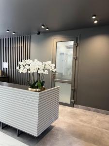 a lobby with a reception desk with white flowers in it at Prestige Apartment in Mykolaiv
