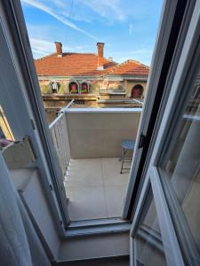 una vista desde la ventana de un balcón con una casa en Apartman Bibi centar, en Niš