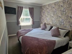 ペイントンにあるAmbassador Guest Houseのベッドルーム1室(毛布、窓付)